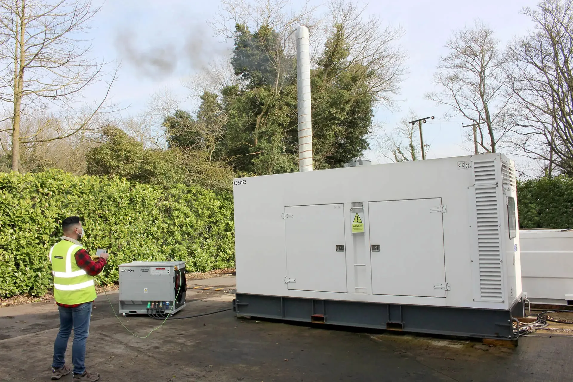 Technician running an Avtron load bank on a diesel standby generator
