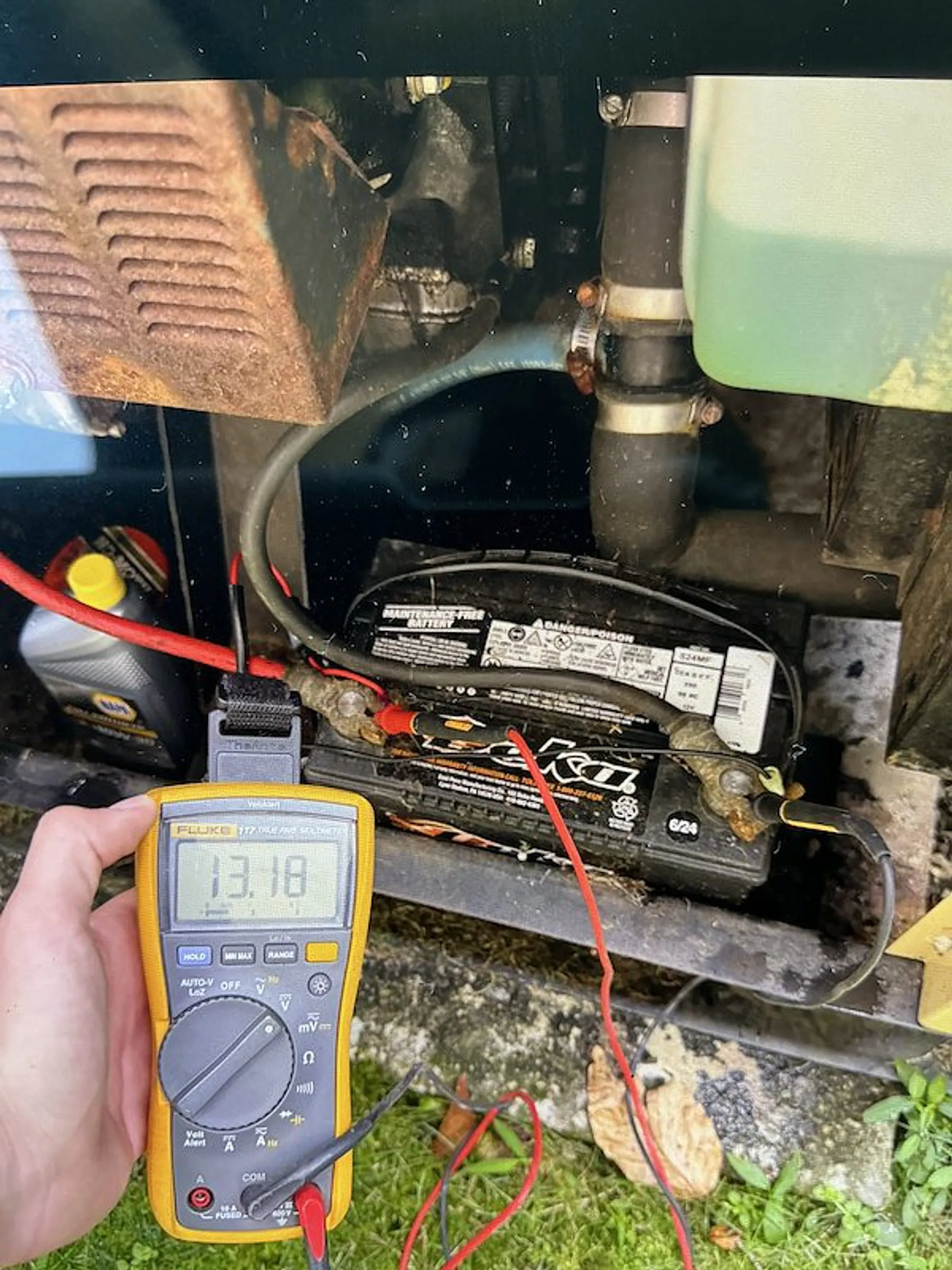 Technician checking battery voltage on a standby generator