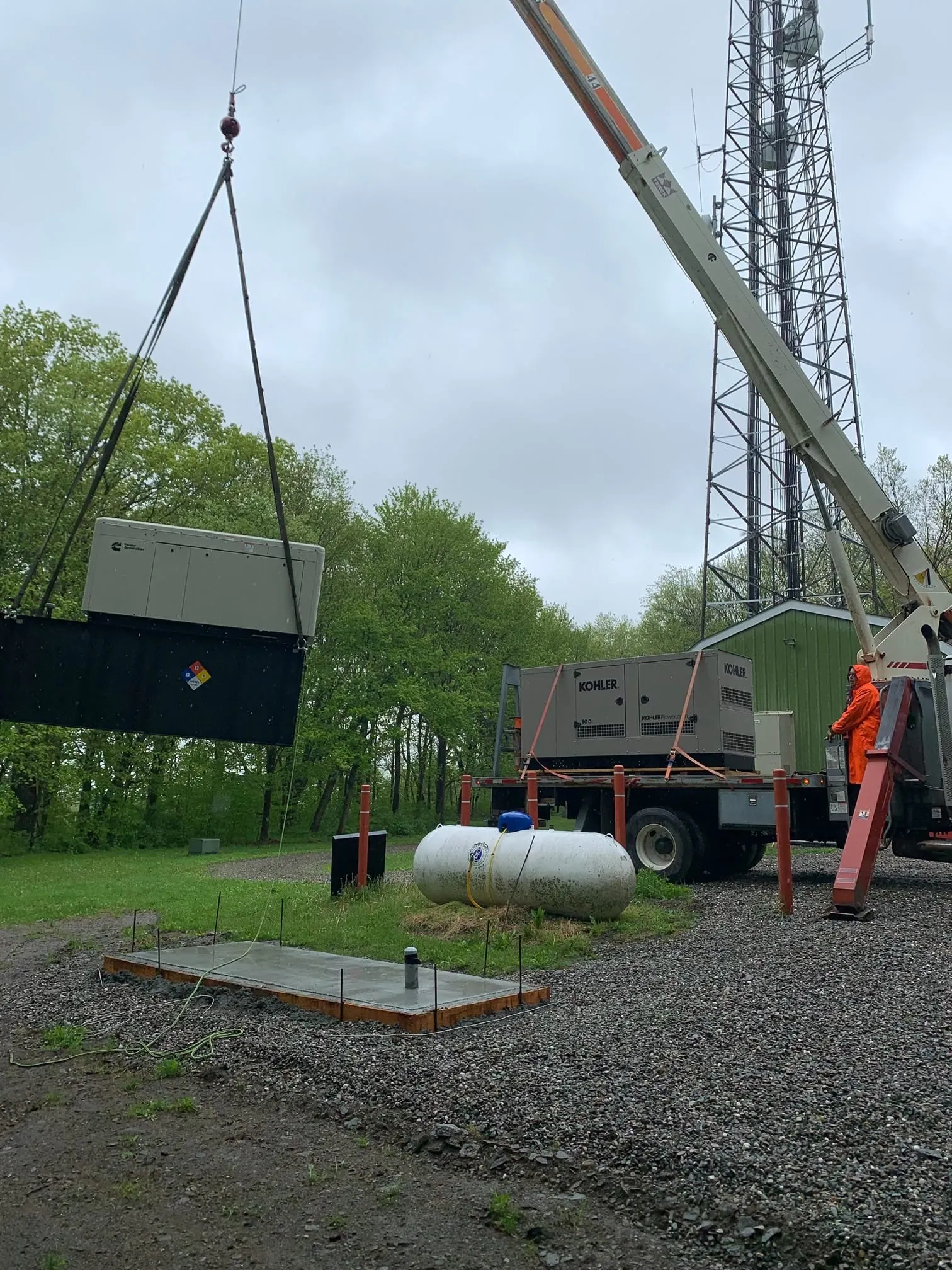 Crane setting a Kohler commercial generator onto its concrete pad