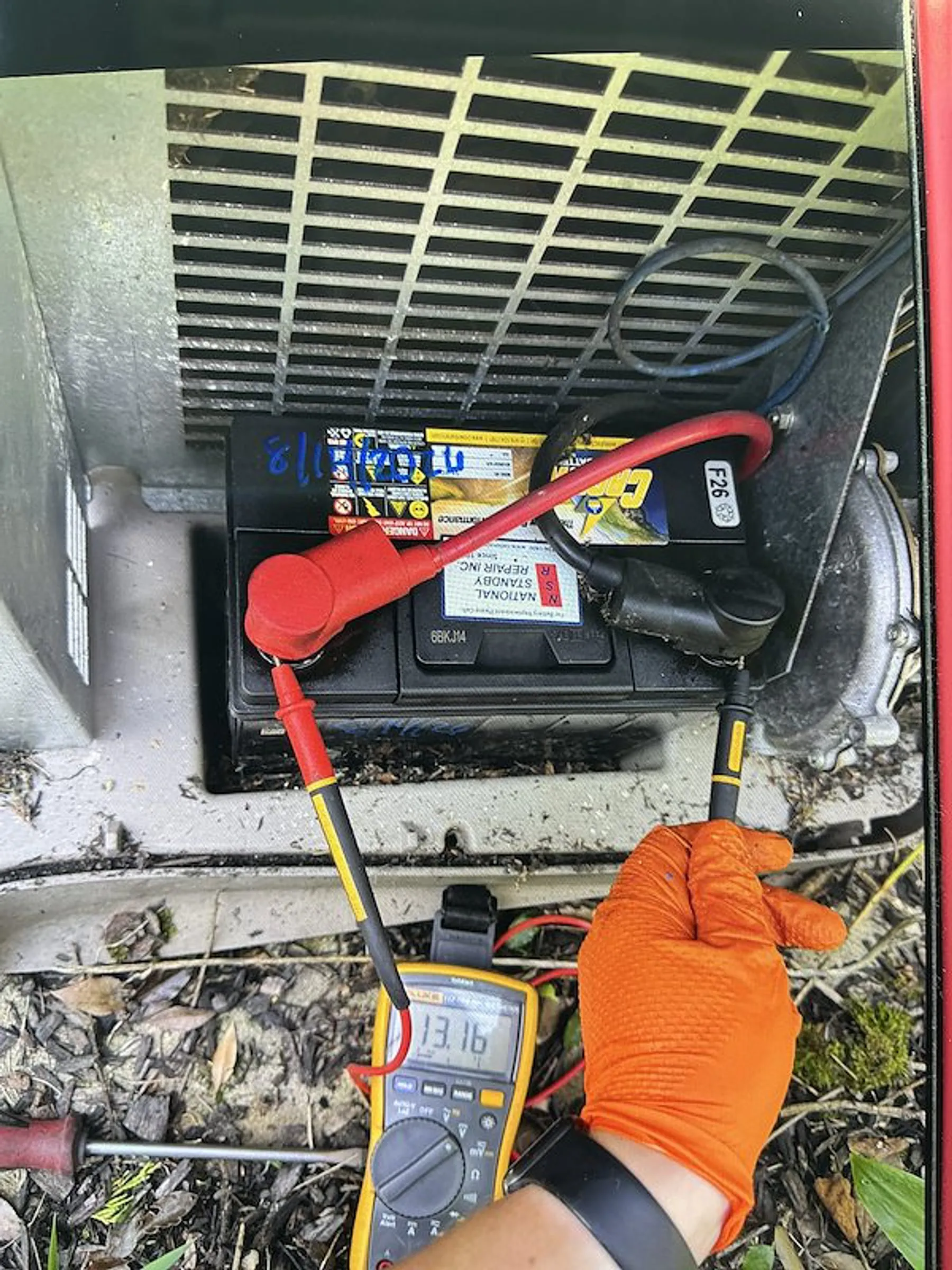 National Standby Repair technician testing a standby generator battery with a multimeter in Danbury