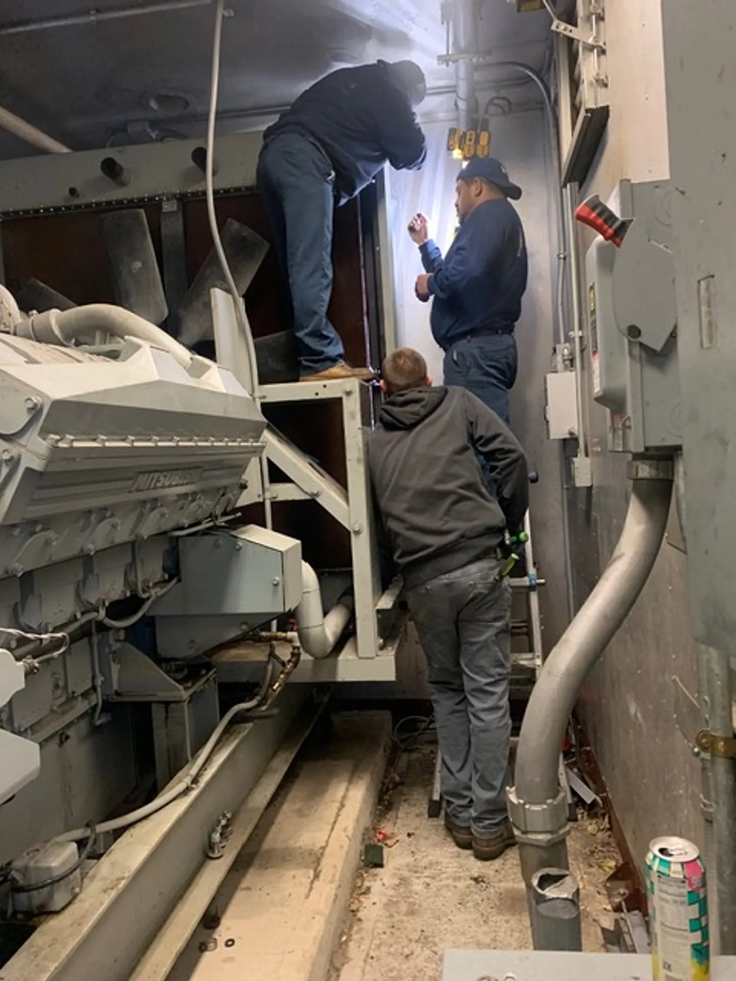 National Standby technicians working on a generator in a plant room
